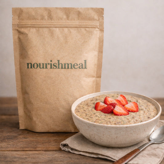 Bowl of nourishmeal with strawberries next to a 'nourishmeal' package on a wooden surface.
